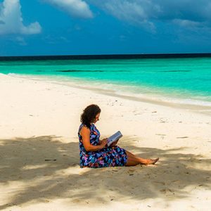 Maldives Holidays Constance Halaveli Resort Woman Reading On Beach