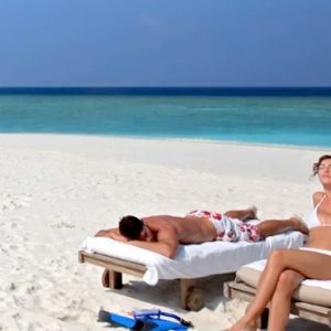 Couple Sunbathing On Sandbank Six Senses Laamu Maldives Holidays